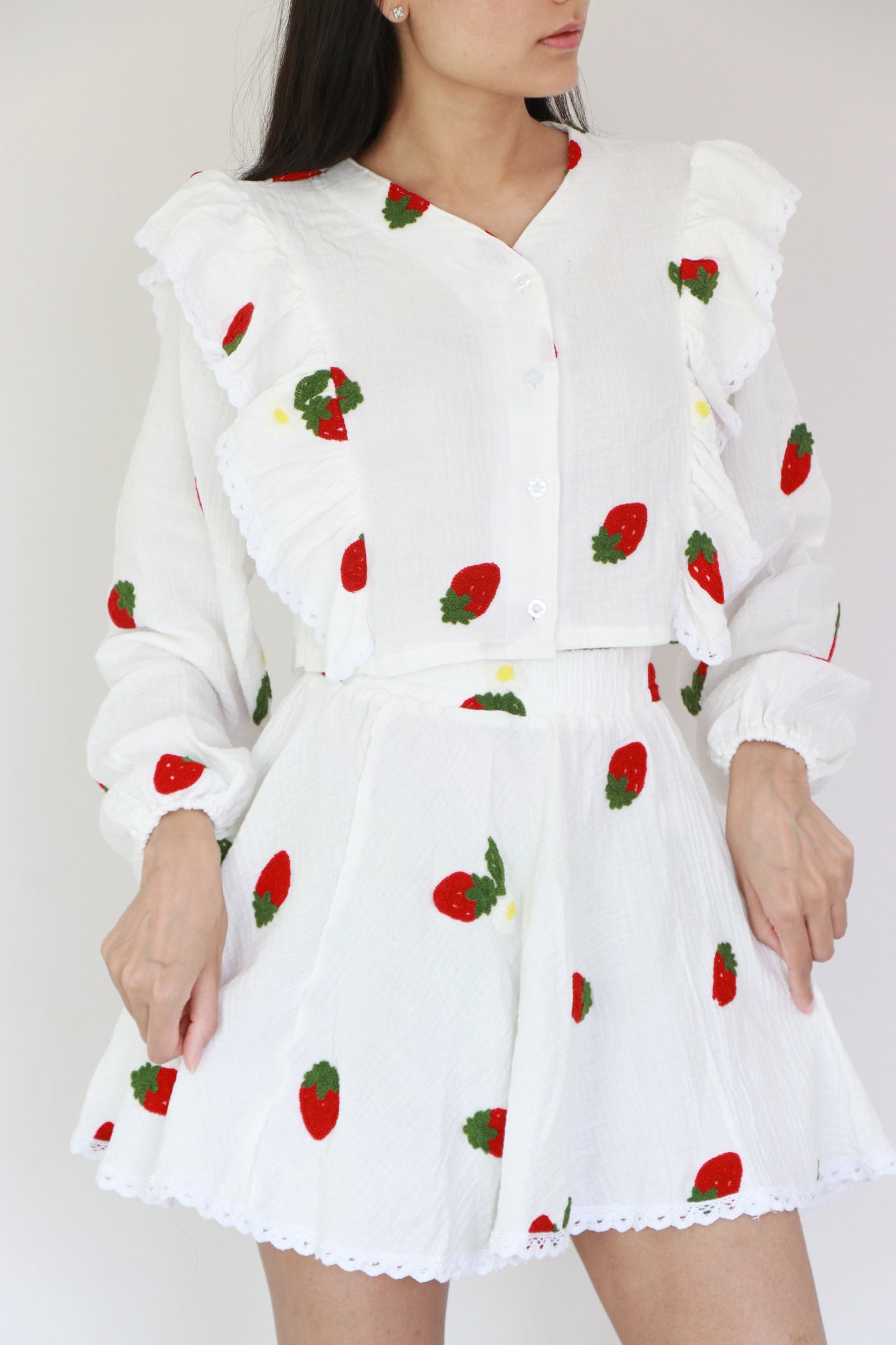 Two-piece co-ord set in natural cotton with red embroidered crop top and flared mini skirt with frills